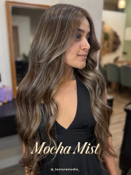 This is my signature sun-kissed look. The Mocha Mist balayage gives you soft, face-framing highlights that grow out seamlessly. It's the perfect low-maintenance color for a natural, radiant glow.