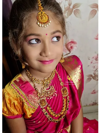 A sweet, candid shot of our little "Gombe". This angle captures her playful personality and the beautiful details of her traditional jewelry and soft makeup.