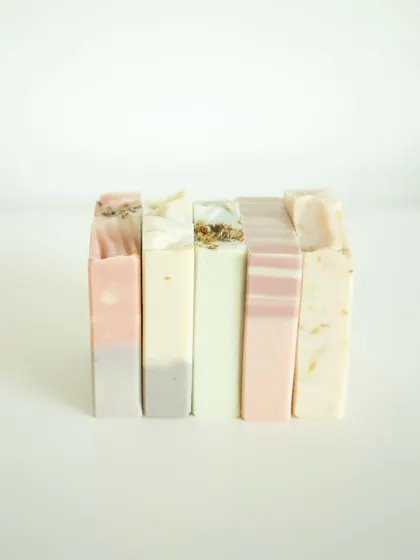 This stack shows the beautiful, natural variety in my soap collection. From left to right: Lavender Patchouli, Neroli Patchouli, Eucalyptus Tea Tree & Rosemary, Flower Market, and Jasmine Calendula. Each bar is handcrafted with its own unique blend of scents and skin-loving ingredients.
