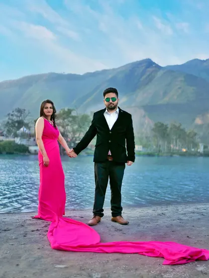 A full-length portrait of the couple holding hands by the river, with the bride's long dress trailing behind her. This shot captures both the couple and the beautiful scenery.