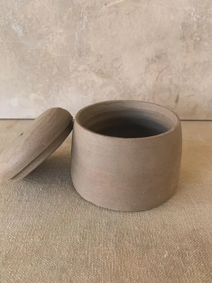 A simple, elegant lidded jar in its raw state. The clean lines and smooth surface are a testament to the skill of wheel-throwing.