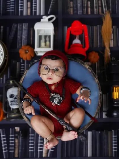 A magical start for a little wizard. This Harry Potter themed newborn shoot is one of my most popular creative concepts. I provide all the props, from the glasses and wand to the library backdrop, for a truly unique first portrait.