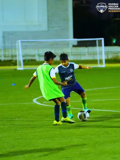 A player demonstrates excellent balance and control as he maneuvers the ball past a defender.