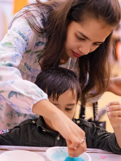 A mother helping her son with a craft activity. I love planning events that families can enjoy together.