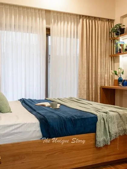 A wider view of the bedroom, showing the relationship between the bed and the integrated study nook. The consistent use of wood tones and a blue and green color palette creates a harmonious and restful environment.
