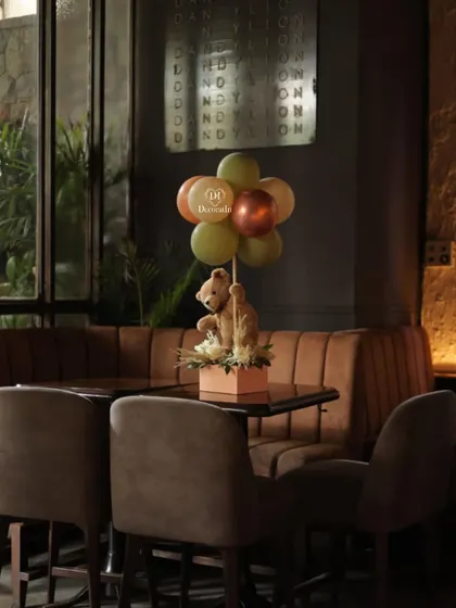 A wider shot of the teddy bear centerpiece on a table.
