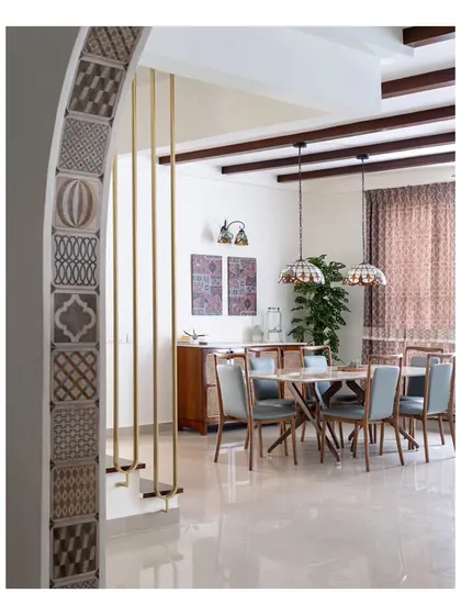 A view from the foyer into the dining area of the "Spanish Country Home." The arch, accented with patterned tiles and decorative brass pipes, frames the dining space, where we transformed an old penthouse into a cozy and charming casa.