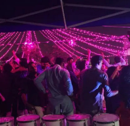 A group of employees dancing under the festive lights at their company's Diwali event.