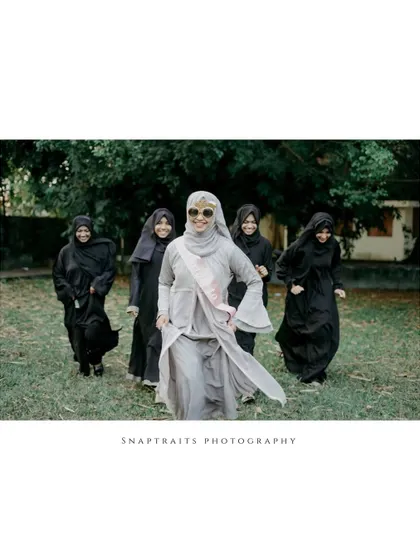 The bride and her bridesmaids, all dressed in black, walk together in this stylish and fun shot from the bridal shower.