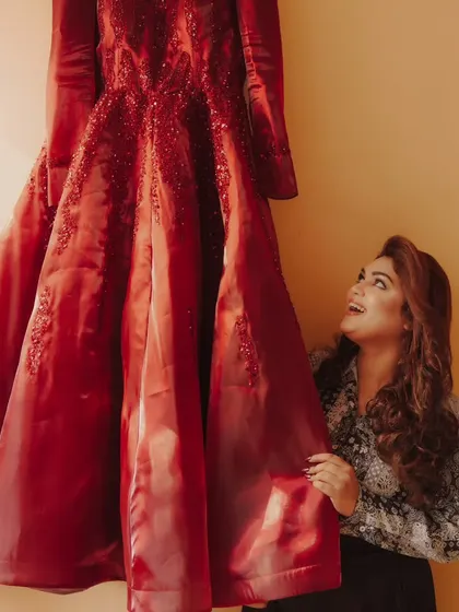 A creative shot of a bride looking up at her hanging wedding gown, a moment of anticipation and excitement.