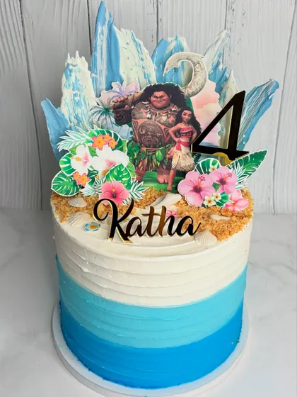 We love bringing your kids' favorite characters to life! This Moana-themed birthday cake features an ocean-inspired blue ombre design, crushed biscuit sand, and custom toppers to create a magical island scene.