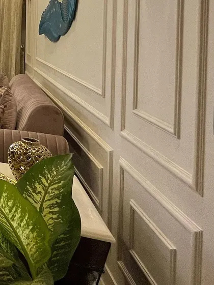 A close-up of the POP moulding, or wainscoting, on the living room wall. This traditional detail adds a sense of structure and timeless elegance to any room.