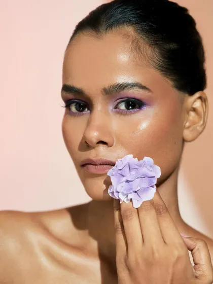 This creative shot with a flower highlights the beautiful skin texture and the way the highlighter catches the light.