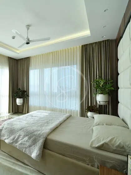 Another angle of the rustic-minimalist bedroom, showing the full height of the dramatic upholstered headboard. The room is filled with natural light, creating an airy and serene atmosphere.