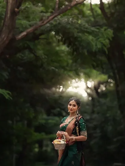A bride in a forest setting, holding a basket of flowers. This portrait has a charming, fairytale quality, blending her elegance with the beauty of nature.