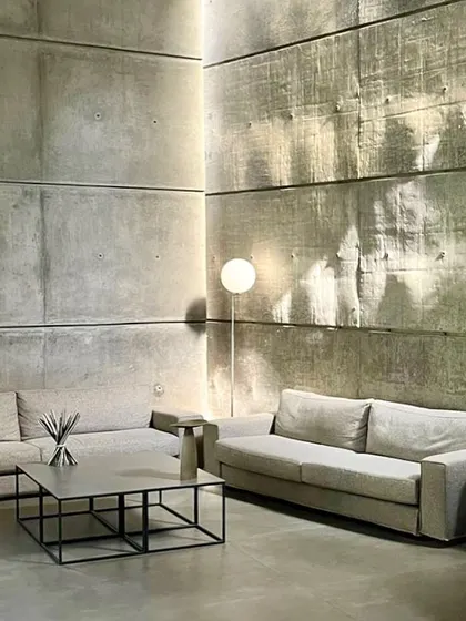 In the 'House of Stories', light from unseen sources washes over the textured concrete walls, making the hard material feel as soft as fabric. This effect is central to our design philosophy of using light as a primary architectural material to shape mood and perception.