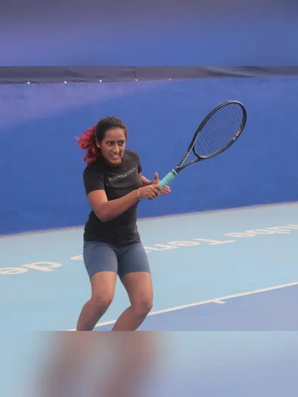 Following through on a forehand during a match. I teach my students how to generate power and maintain balance, key components for a strong, consistent game.