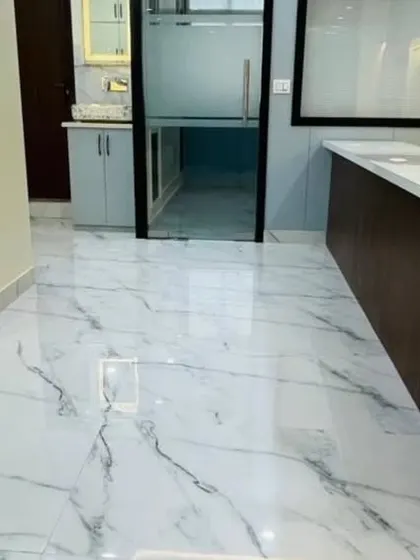 This shot highlights the glossy marble flooring and the clean, open pathways in the office. Good flooring and a clear layout are key to making a smaller space feel bigger.
