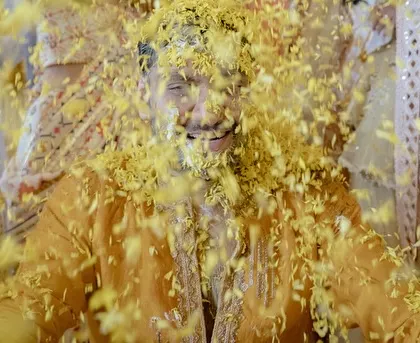 The groom enjoying the 'Phoolon Ki Holi' as he is showered with marigold petals by his friends and family.
