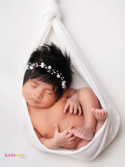 Another angle of the delicate sling pose, showing the baby's peaceful expression and beautiful thick hair.