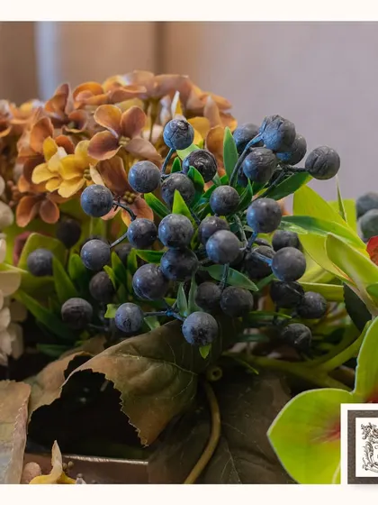 A macro view of the artificial blueberries in the arrangement, adding a touch of texture and realism to the overall design.
