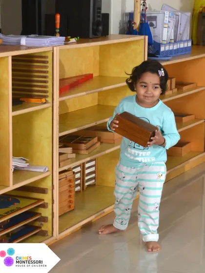 A child independently selects a material from the shelf. Our classrooms are designed with everything at the child's level to promote autonomy and empower them to take charge of their learning.