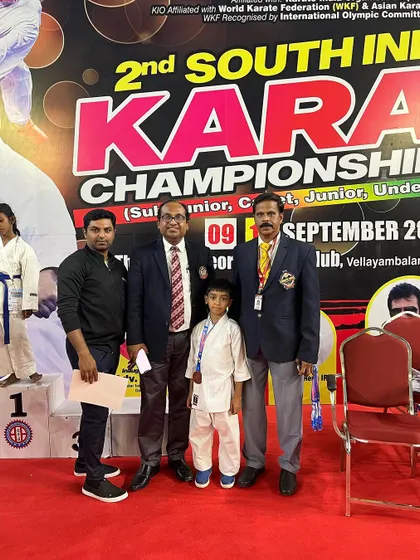 Standing with my son and officials at the 2nd South India Karate Championship. His success is a proud moment for our entire academy.