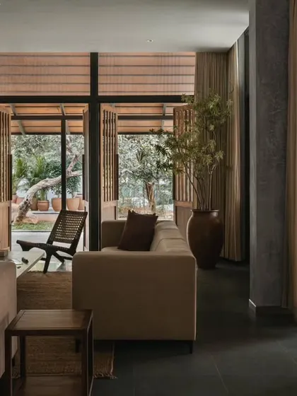 The main living room features large, foldable doors that open completely to the outside. This allows for natural ventilation and an uninterrupted view of the garden, making the lounge feel like a part of the landscape.