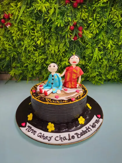 An adorable "Ghar Chalo" themed cake featuring a cute elderly couple. A heartwarming design for celebrating family and togetherness.