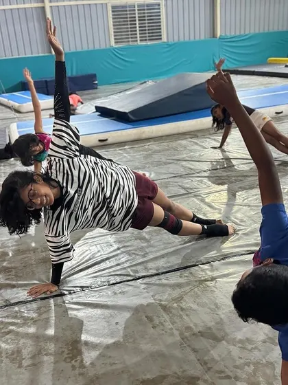 A group of students holds a side plank, working together to build the core strength that is essential for all gymnastics skills.