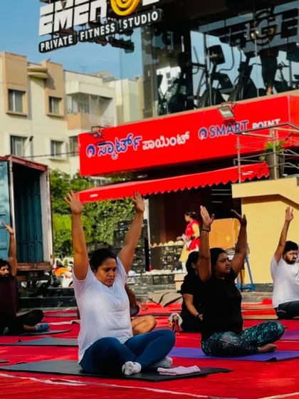 Members practicing a seated meditation pose in front of our studio, finding a moment of peace and stillness together.