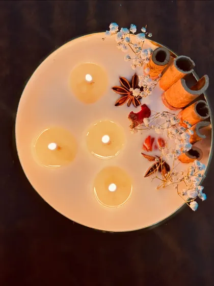 Another angle of the lit urli candle, showing the gentle flicker of its multiple wicks.