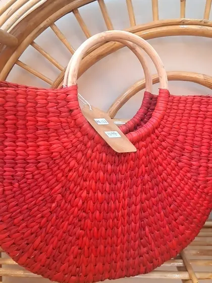 A close-up of our red woven handbag, showing the texture of the seagrass and the smooth finish of the wooden handles. This is a great option for retailers looking for colorful, eco-friendly fashion.