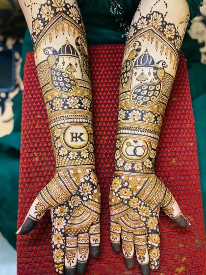 A complete bridal mehndi look combining traditional and personal elements. This design includes peacock and palace motifs, along with the couple's initials "HK" and a symbol of their union with intertwined rings.