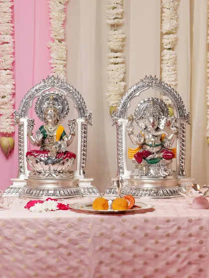 This pair of silver-plated Lakshmi and Ganesha idols, each framed by an elegant arch, creates a harmonious and auspicious display. They are perfect for invoking blessings of wealth and wisdom during festive seasons.