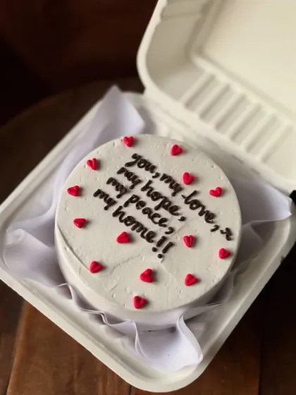 A heartfelt message on a simple white bento cake: "you, my love, my hope, my peace, my home!!" Surrounded by tiny red hearts, it’s a beautiful and personal declaration of love.