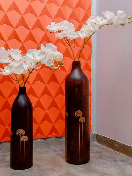 The repetition of form in these wooden vases with delicate inlay work creates a simple yet elegant decorative corner.