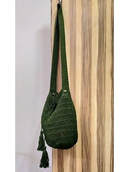 This custom-made jhola bag in a deep olive green features a drawstring closure and handmade tassels. It's a perfect example of how we can tailor a design to your favorite color.