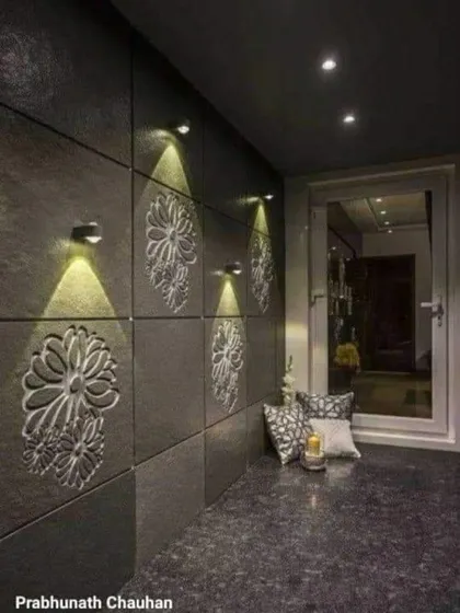 An accent wall can completely change a space. Here, we used dark, carved stone panels and positioned warm spotlights to highlight the intricate floral patterns, creating an elegant and sophisticated entryway.