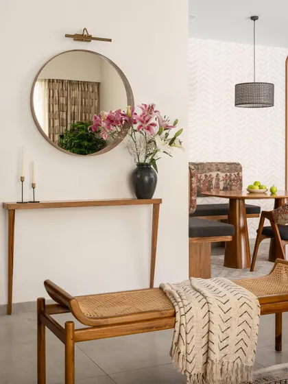 The passage leading to the dining area in 'Palaash' features a sleek console table with a unique angular leg fixed to the wall for support. This detail showcases our approach to creating functional art within the home.