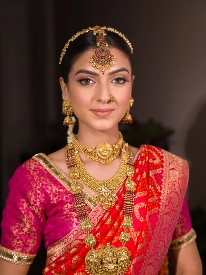 A portrait of timeless beauty. The makeup is perfectly balanced, with defined eyes, a warm complexion, and a natural lip that allows the stunning gold jewellery to take centre stage.