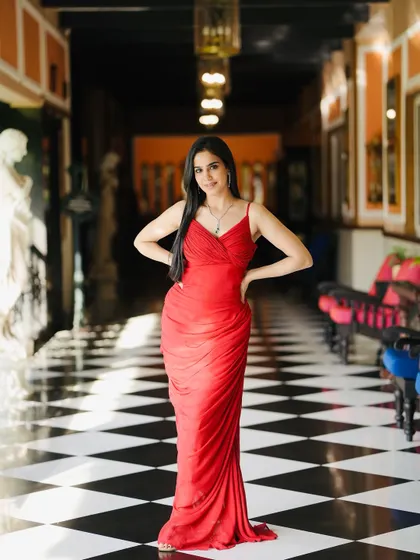 A powerful, confident pose in the red gown, standing in a classic checkered hallway.