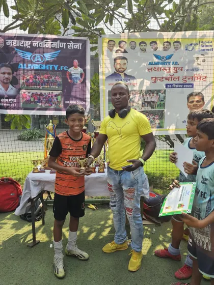 A TFA player receiving an individual award at the Almighty FC football tournament.