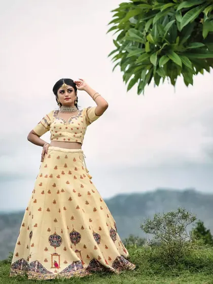 This cream-colored embroidered lehenga is perfect for outdoor settings, creating a look that is both elegant and ethereal.