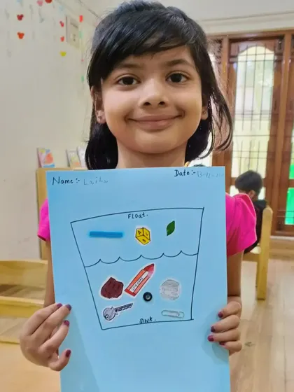 A student shows her worksheet where she has sorted objects that float and sink.