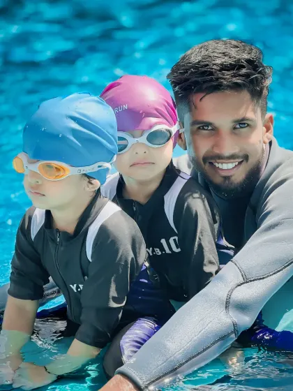 A coach poses with two of his students. This photo reflects the strong, trusting bonds that form between our instructors and the children they teach.