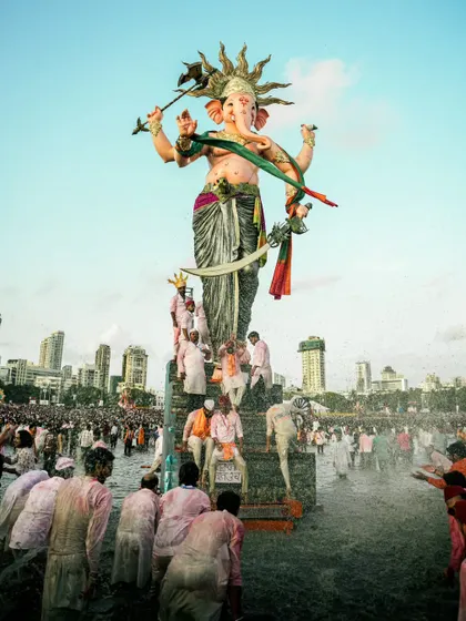 Devotees gather in the water at Girgaon Chowpatty for the visarjan (immersion) of the Mumbaicha Raja idol. This image captures the energy and devotion of the crowd as they bid farewell.