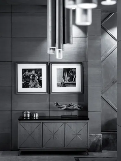 A black and white photograph of a quiet corner in The Restaurant at Hibiscus. This image highlights the textures and forms of the custom furniture and paneling, showcasing the timeless elegance of the design.