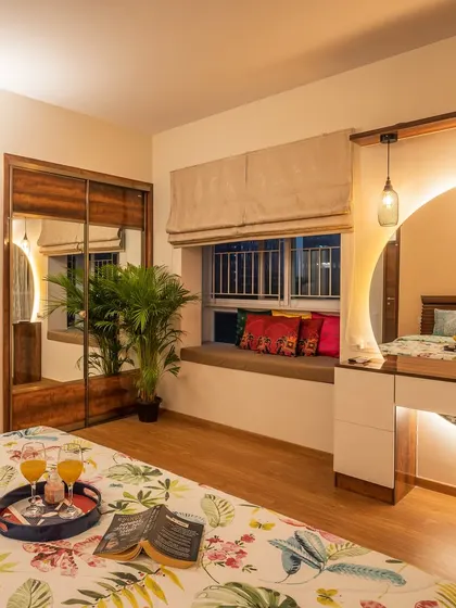 We designed this bedroom with warmth and functionality in mind. It features a custom vanity with a backlit circular mirror, a cozy window seat, and a sliding wardrobe with a full-length mirror.