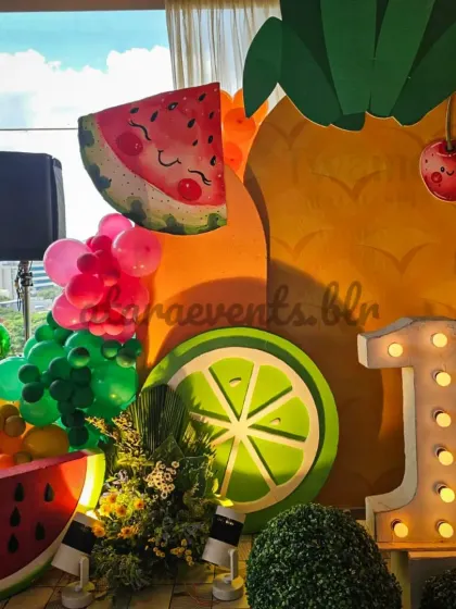 A close-up of the main stage highlights the cheerful, smiling fruit characters and the large marquee number, creating a perfect photo opportunity for the birthday child.